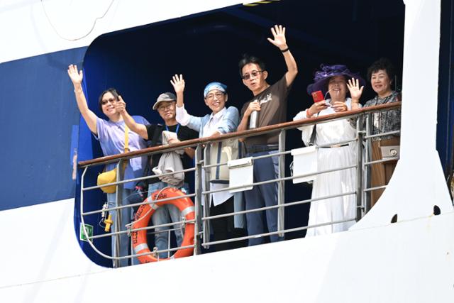 지난해 8월 중국인 단체관광객을 태운 크루즈선 상하이 블루드림스타호에서 제주 입항을 기다리는 승객들이 손을 흔들고 있다. 제주도사진기자회