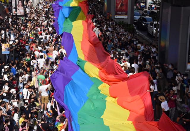 지난해 6월 태국 방콕에서 열린 성소수자 인권의 달 기념 퍼레이드에 LGBTQ+ 지지를 의미하는 6색 대형 무지개 현수막이 나부끼고 있다. 방콕=허경주 특파원
