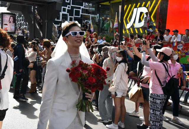 지난해 6월 태국 방콕에서 열린 성소수자 인권의 달 기념 퍼레이드에서 한 참가자가 결혼식 복장을 한 채 행진하고 있다. 방콕=허경주 특파원