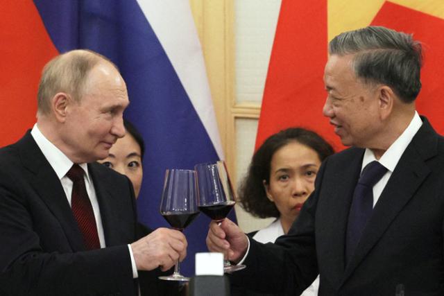 베트남을 국빈방문한 블라디미르 푸틴(왼쪽) 러시아 대통령과 또럼 베트남 국가주석이 20일 하노이 오페라하우스에서 열린 만찬에서 건배를 하고 있다. 하노이=로이터 연합뉴스