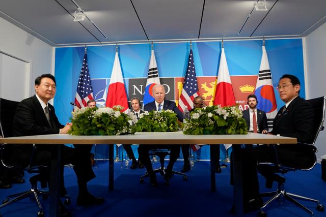 윤석열(사진 앞줄 쪽) 대통령과 기시다 후미오(오른쪽) 일본 총리, 조 바이든(사진 둘째줄) 미국 대통령이 2022년 7월 스페인 마드리드에서 열린 북대서양조약기구(NATO·나토) 정상회의에서 한미일 3자 정상회의를