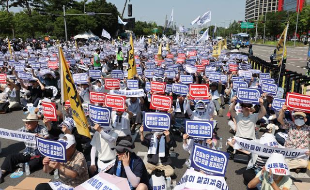 대한의사협회가 집단 휴진에 돌입한 18일 서울 여의도에서 전국 의사 총궐기대회에서 참석자들이 손팻말을 들고 구호를 외치고 있다. 뉴시스