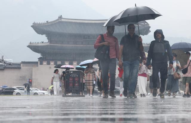 서울 등 중부지방에 비가 내린 지난 22일 서울 종로구 광화문광장에서 외국인 관광객들이 우산을 쓰고 이동하고 있다. 뉴시스