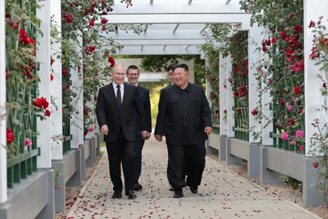 블라디미르 푸틴(왼쪽) 러시아 대통령과 김정은 북한 국무위원장이 20일 금수산 영빈관 정원구역에서 함께 산책을 하며 단독 회담을 하고 있다. 평양=노동신문 뉴스1