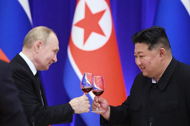 북한을 국빈 방문한 블라디미르 푸틴(왼쪽) 러시아 대통령과 김정은 북한 국무위원장이 지난 19일 평양에서 열린 국빈 만찬 행사에서 건배하고 있다. 평양=로이터 연합뉴스