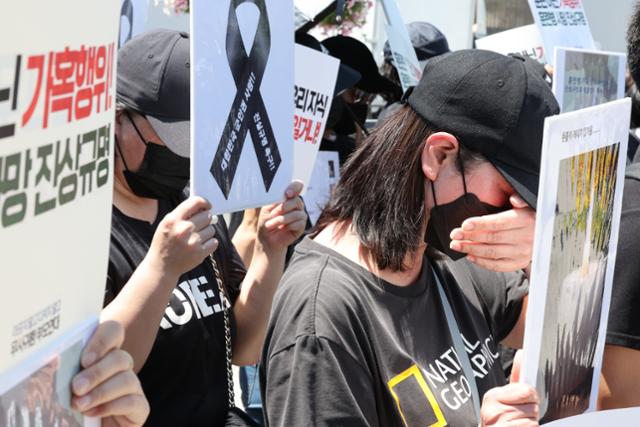 4일 오전 서울 용산구 전쟁기념관 앞에서 열린 육군 12사단 훈련병 가혹행위 사망 사건 규탄 및 진상규명 촉구 기자회견에서 군에 입대한 자녀를 둔 참가자들이 눈물을 닦고 있다. 뉴스1
