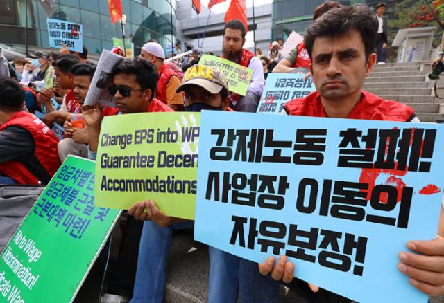 '2024년 세계노동절 - 이주노동자 메이데이 집회'에 참석한 이주노동자가 사업장 이동의 자유 보장을 촉구하는 피켓을 들고 있다. 뉴시스