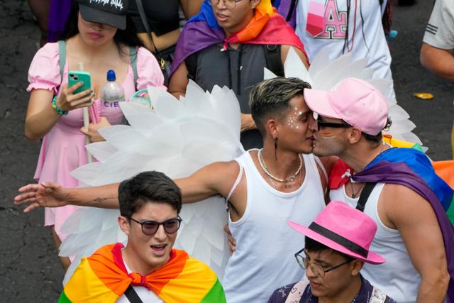 22일 에콰도르 키토에서 열린 프라이드 행사에서 퍼레이드에 참가한 커플이 키스를 나누고 있다. 키토=AP 연합뉴스