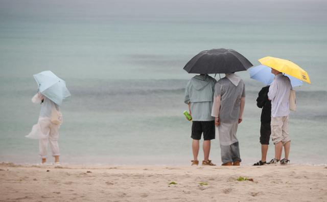 장마전선이 북상 중인 27일 오후 제주시 구좌읍 월정해수욕장에서 우산을 쓴 관광객들이 장맛비가 내리는 여름 정취를 느끼고 있다. 뉴시스