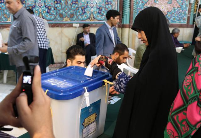 지난 28일 오전 테헤란 호세이니예 에르샤드 모스크 투표소에서 젊은 여성 유권자가 투표용지를 투표함에 넣고 있다. 테헤란=연합뉴스