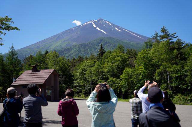 일본 야마나시현을 찾은 관광객들이 19일 후지산을 촬영하고 있다. 야마나시=EPA 연합뉴스