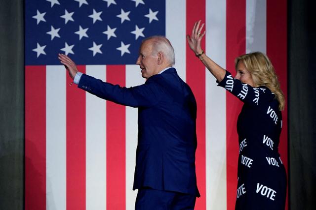 조 바이든(왼쪽) 미국 대통령과 영부인 질 바이든 여사가 지난달 28일 미국 노스캐롤라이나주 롤리 유세를 마치고 무대를 떠나며 손을 흔들고 있다. 롤리=로이터 연합뉴스