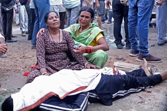 2일 인도 북부 우타르프라데시주 하트라스 지역의 병원 밖에서 한 여성이 압사 사고로 숨진 가족의 시신 옆에서 슬퍼하고 있다. 하트라스=AP