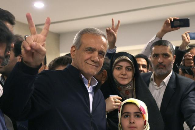 이란 대통령 보궐선거에 출마한 개혁파 정치인 마수드 페지시키안(가운데) 후보가 지난달 28일 테헤란에서 1차 투표를 마친 뒤 손가락으로 승리의 'V' 사인을 그려 보이고 있다. 테헤란=AFP 연합뉴스