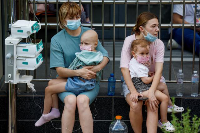 8일 러시아의 미사일 공격을 받은 우크라이나 키이우의 오크흐마트디트 어린이병원에서 보호자들이 아이를 안고 대피해 있다. 키이우=로이터 연합뉴스