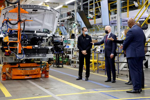 조 바이든(왼쪽 두번째) 미국 대통령이 2021년 11월 미국 미시간주(州)의 제너럴모터스(GM) 전기차 생산 공장에 방문해 기업 관계자의 발언을 듣고 있다. 미시간=로이터 연합뉴스
