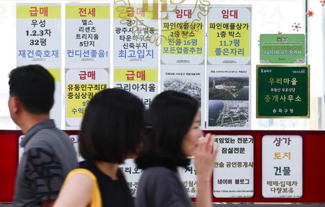 10일 서울 시내의 부동산 사무실 앞으로 시민들이 지나가고 있다. 국토교통부는 이날부터 중개대상물에 대한 공인중개사의 확인과 설명 의무를 강화하는 공인중개사법 시행령과 시행규칙 개정안을 시행한다고 밝혔다. 뉴시스