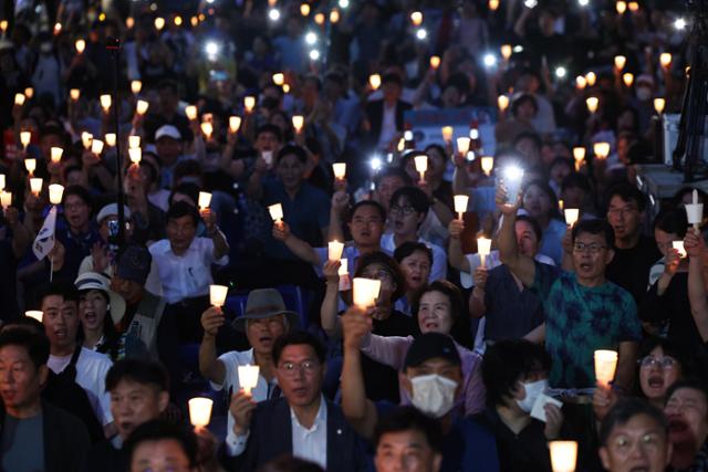 19일 서울 종로구 동화면세점 앞에서 열린 '채상병 1주기 군 사망 사건 피해자 추모 촛불문화제'에 참여한 야당 정치인들과 시민들이 특검을 요구하는 구호를 외치고 있다. 뉴시스