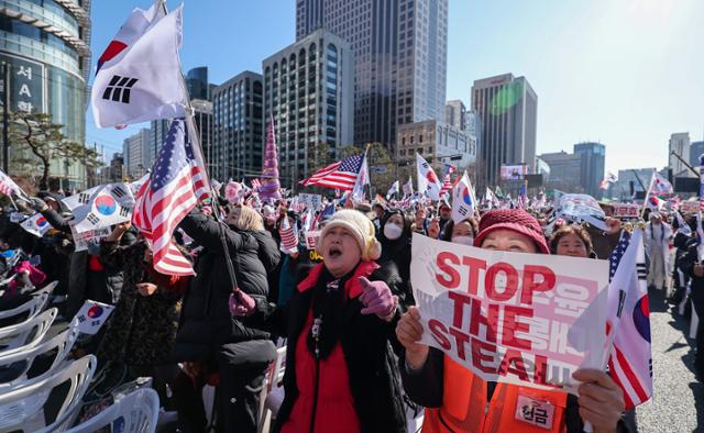 지난달 25일 서울 종로구 동화면세점 일대에서 대한민국바로세우기운동본부 주최로 열린 윤석열 대통령 탄핵 반대 집회에서 지지자들이 손팻말, 태극기, 성조기를 들고 구호를 외치고 있다. 뉴스1