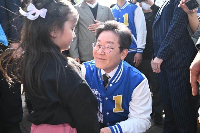 이재명 당시 더불어민주당 대표가 지난해 3월 인천 계양구 선거 유세에서 한 아이와 인사하고 있다. 고영권 기자