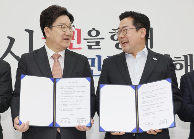 1일 서울 여의도 국회에서 더불어민주당 박찬대 당대표 직무대행 겸 원내대표(오른쪽)와 국민의힘 권성동 원내대표가 추경안 합의문에 서명한 뒤 미소짓고 있다. 연합뉴스