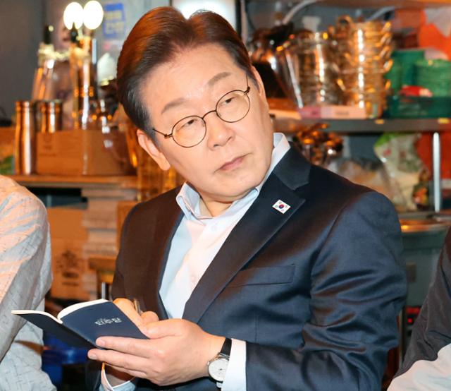이재명 더불어민주당 대선후보가 1일 서울 종로구의 한 포장마차에서 열린 비전형 노동자 간담회에서 메모를 하고 있다. 대법원 전원합의체는 이날 이 후보에게 무죄를 선고한 원심 판결을 파기하고 사건을 서울고법으로 돌려보