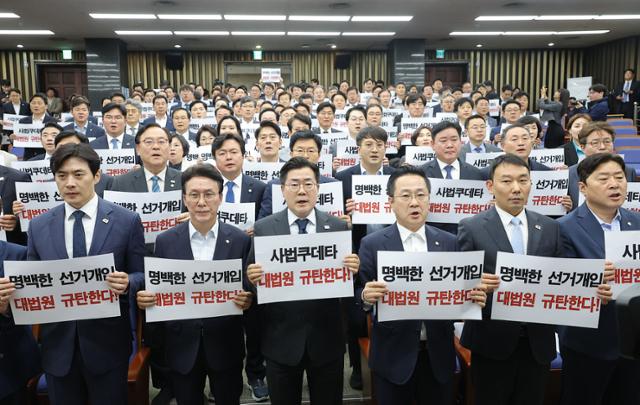 더불어민주당 의원들이 1일 서울 여의도 국회에서 긴급 의원총회를 한 뒤 '사법 쿠데타' '명백한 선거 개입' 등 표현을 사용하며 대법원을 규탄하는 구호를 외치고 있다. 이날 대법원은 이 후보의 공직선거법 위반 사건 
