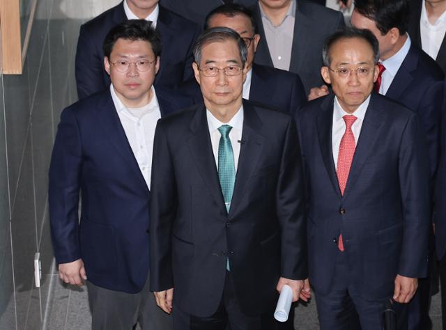 한덕수(앞줄 가운데) 전 대통령 권한대행 국무총리가 2일 대선 출마 선언을 위해 추경호(오른쪽) 국민의힘 의원 등과 함께 서울 여의도 국회 소통관으로 이동하고 있다. 연합뉴스