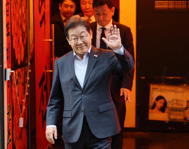 이재명 더불어민주당 대선 후보가 1일 서울 종로구의 한 포장마차에서 열린 비전형 노동자 간담회를 마치고 나오며 손을 들어 보이고 있다.대법원 전원합의체는 이날 이 후보에게 무죄를 선고한 원심 판결을 파기하고 사건을