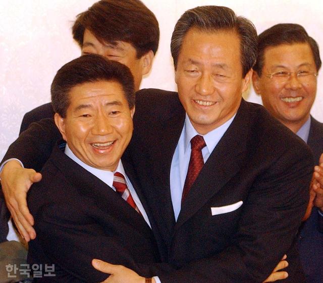 2002년 11월 16일 노무현 새천년민주당 대선후보와 정몽준 국민통합21 대선후보가 국민여론조사에 의한 후보단일화에 전격 합의한 뒤 활짝 웃으며 얼싸안고 있다. 한국일보 자료사진