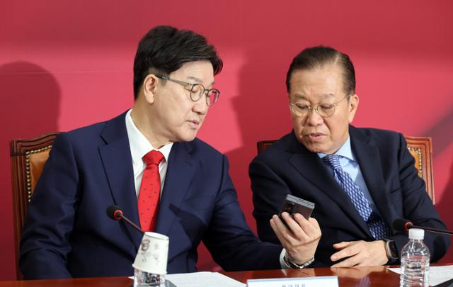 국민의힘 권영세(오른쪽) 비상대책위원장과 권성동 원내대표가 8일 국회에서 열린 비상대책위원회의에서 휴대전화를 보며 대화하고 있다. 연합뉴스