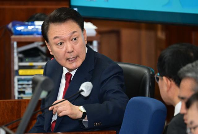 12·3 비상계엄을 선포해 내란 우두머리 혐의로 재판에 넘겨진 윤석열 전 대통령이 4월 21일 오전 서울 서초구 서울중앙지법 417호 법정에 앉아 변호인단과 대화를 하고 있다. 사진공동취재단