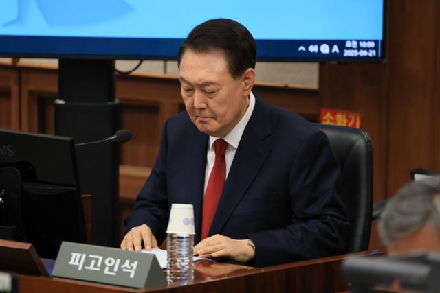 12·3 불법계엄을 선포해 내란 우두머리 혐의로 재판에 넘겨진 윤석열 전 대통령이 4월 21일 서울 서초구 서울중앙지법 417호 법정에 앉아 재판 시작을 기다리고 있다.뉴시스