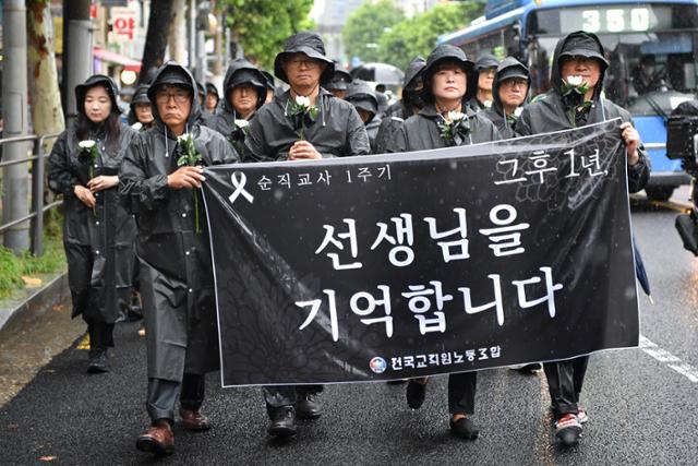 전국교직원노동조합 조합원들과 시민들이 서이초 교사 순직 1주기인 지난해 7월 18일 서울 서초구 서이초등학교 앞에서 국화꽃을 들고 행진하고 있다. 신용주 인턴기자