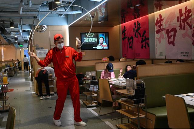 3월 14일 중국 베이징의 한 식당에서 점원이 일하고 있다. 기사 내용과는 직접적 관련이 없다. 베이징=AFP 연합뉴스