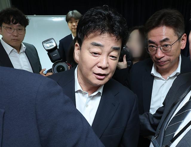 백종원(가운데) 더본코리아 대표가 3월 28일 서울 서초구 스페이스쉐어 강남역센터에서 열린 정기 주주총회를 마친 뒤 주총장을 빠져나가고 있다.뉴스1