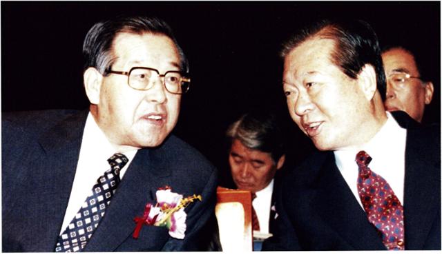 1997년 10월 27일 김대중(앞줄 오른쪽) 새정치국민회의 총재가 김종필(왼쪽) 자유민주연합 총재의 자택을 방문해 대선 후보 단일화 협상을 완전히 매듭지었다. 사진은 두 사람이 함께 한 행사에 참석해 있는 모습. 
