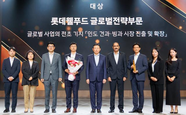 신동빈(왼쪽 다섯 번째) 롯데그룹 회장과 '2025 롯데어워즈 대상'을 수상한 롯데웰푸드 글로벌전략 부문 관계자들이 사진을 찍고 있다.롯데그룹 제공