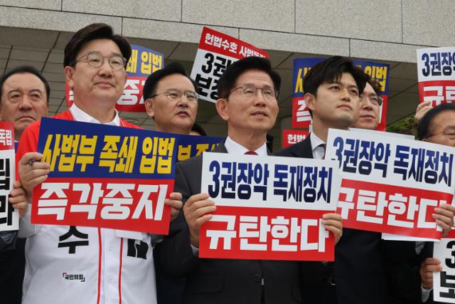 김문수(가운데) 국민의힘 대선 후보와 김용태(오른쪽), 권성동 공동선거대책위원장이 15일 서울 서초동 대법원 앞에서 열린 사법부 수호 및 더불어민주당 규탄대회에 참석해 손피켓을 들고 있다. 뉴스1