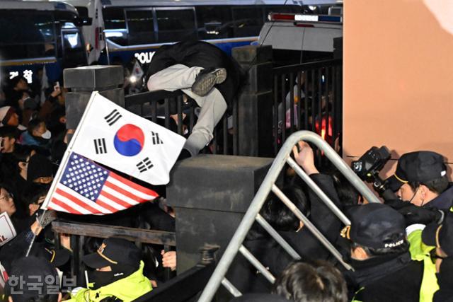 1월 18일 서울 마포구 서부지법에서 윤석열 전 대통령 지지자가 법원 담장 철제울타리를 넘어가고 있다. 박시몬 기자