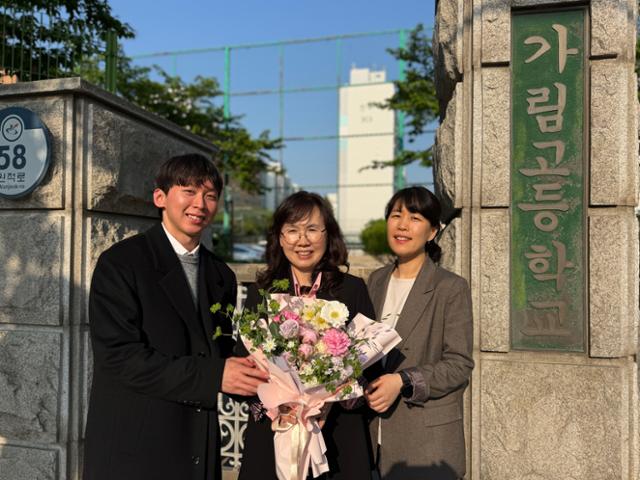 원주현(맨 오른쪽)·기중현(맨 왼쪽) 교사가 지난 12일 인천 서구 가림고등학교 앞에서 스승인 심현자 교사에게 스승의 날 꽃다발을 건네준 뒤 웃고 있다. 심 교사는 2000년 인천여고에서 고3이던 원 교사에게 세계사