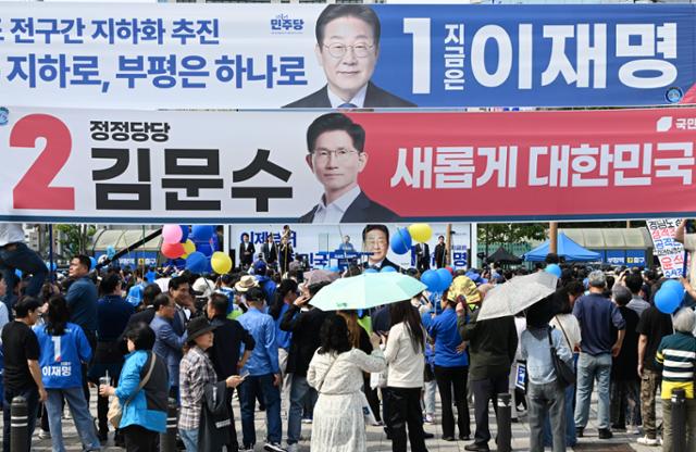 이재명 더불어민주당 대선 후보가 21일 인천 부평구 부평역 북광장에서 열린 집중 유세에 참석해 지지를 호소하고 있는 가운데 김문수 국민의힘 대선 후보의 현수막이 보이고 있다. 인천=고영권 기자