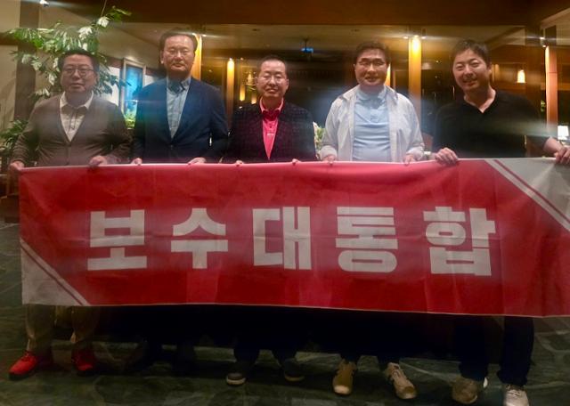 유상범(왼쪽 두번째) 국민의힘 대선 선거대책위 단일화추진본부장, 김대식(오른쪽 두번째) 대외협력본부장 등이 미국 하와이에서 홍준표(가운데) 전 대구시장과 함께 '보수대통합'이 적힌 펼침막을 들어보이고 있다. 김대식 