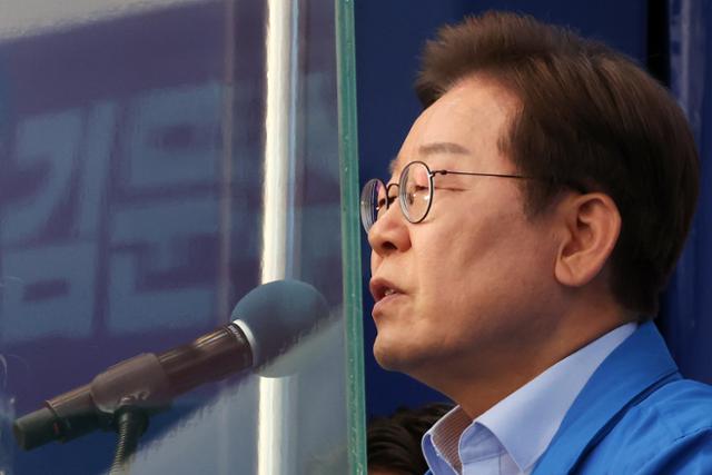 이재명 더불어민주당 대선후보가 21일 인천 계양구 계양역 앞에서 열린 유세에서 연설하는 가운데 방탄 유리에 김문수 국민의힘 대선후보 현수막이 투영되고 있다. 뉴시스