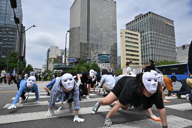 무용수와 시민 등 50여 명이 22일 서울 광화문 이순신동상 앞에서 네 발로 횡단보도를 건너며 자연과 인간의 공생을 강조하는 퍼포먼스를 하고 있다. 정다빈 기자 answer@hankookilbo.com
