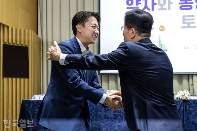 이준석(왼쪽) 개혁신당 대선 후보와 김문수 국민의힘 대선 후보가 19일 서울 중구 서울시청에서 열린 약자와 동행하는 서울 토론회에 참석해 기념촬영을 마친 뒤 악수하고 있다. 하상윤 기자