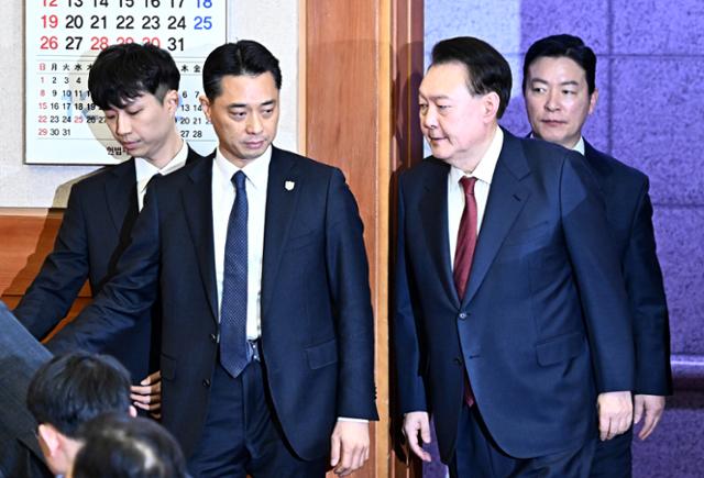 내란 우두머리 혐의로 구속된 윤석열 전 대통령이 1월 23일 오후 서울 종로구 헌법재판소에서 열린 탄핵 심판 4차 변론기일에 출석하고 있다. 김성훈 대통령경호처 차장이 윤 전 대통령을 경호하고 있다. 헌법재판소 제공