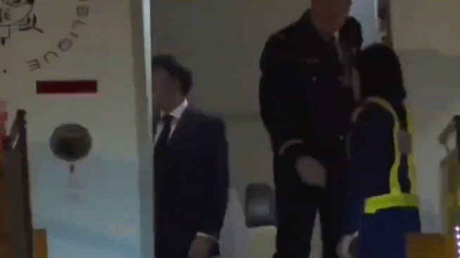 에마뉘엘 마크롱 대통령이 26일 베트남 하노이 공항에서 부인 브리지트 여사에게 얼굴을 맞고 있다. 엑스(X) 캡처