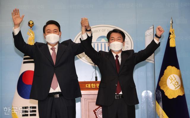 2022년 3월 3일 윤석열(왼쪽) 당시 국민의힘 대선 후보와 안철수 당시 국민의당 대선 후보가 국회 소통관에서 단일화 합의 기자회견을 마친 뒤 맞잡은 손을 번쩍 들고 있다. 한국일보 자료사진