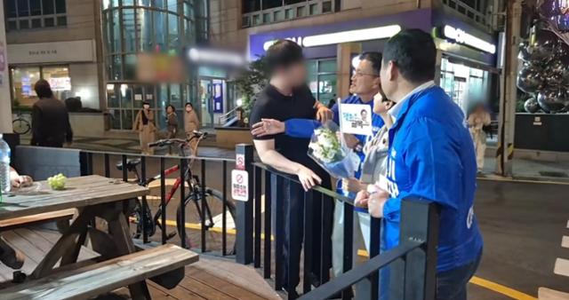 23일 박주민 더불어민주당 의원 유튜브 채널에 올라온 영상의 한 장면. 이날 박 의원은 부산 광안리 일대에서 이재명 민주당 대선 후보를 위한 선거 유세를 하고 있었는데, 검은색 상의를 입은 한 남성(맨 왼쪽)이 박 